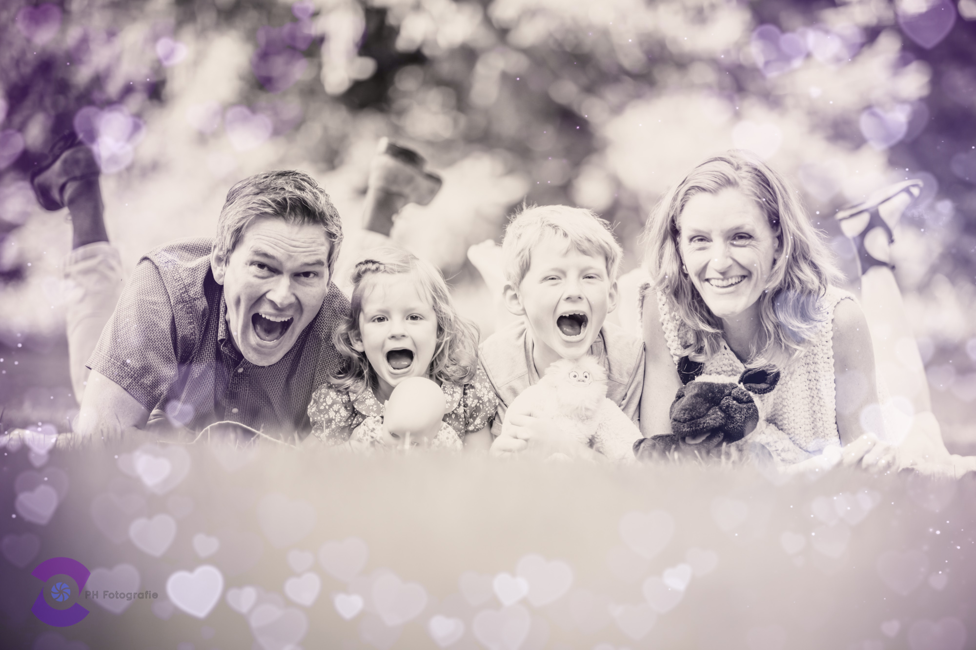 Familie%20liegt%20nebeneinader%20für%20Fotoshooting%20im%20Wenkenpark%20in%20Riehen%20und%20haben%20Spass